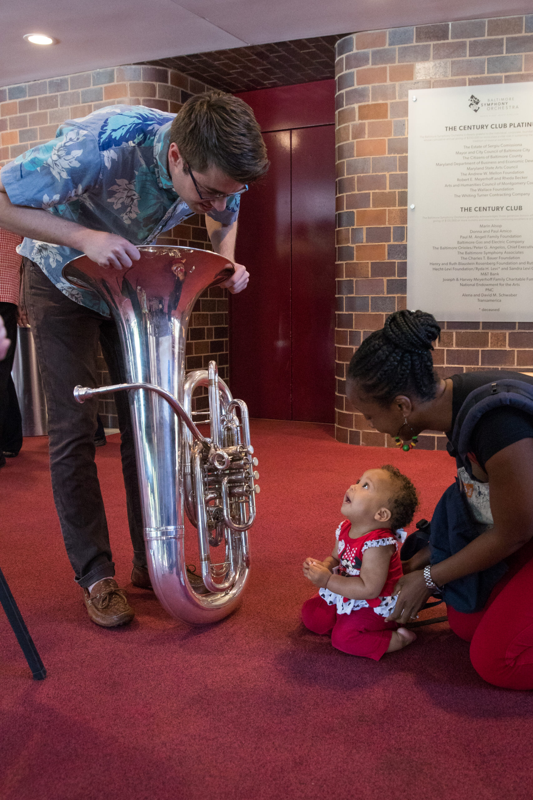 Child looking at a tuba at a BSO Music Box Concert at the Joseph Meyerhoff Symphony Hall